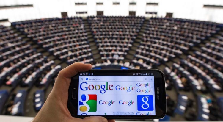 epa04505630 A mobile phone displaying the Google logo is held as members of the European Parliament vote during the plenary session in the European Parliament in Strasbourg, France, 27 November 2014. MEPs will vote on a resolution on consumer rights on the Internet in Europe.  EPA/PATRICK SEEGER